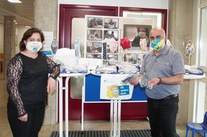 Shilan und Amed Doski zeigen stolz die genähten Masken vor dem Stand in der Zulassungsstelle