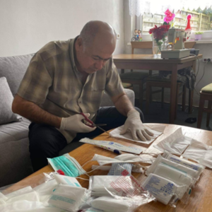 Esmaeel Hussein, ein Beteiligter des Projekts, schneidet den Stoff zu.