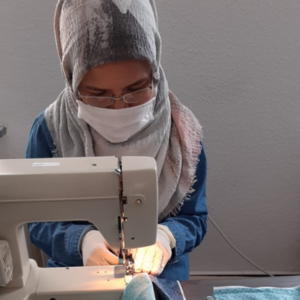 Masoumeh Mozafari, eine Beteiligte des Projekts näht mit einer Nähmaschine.