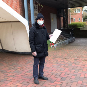 Eziz Xemcivin, ein Beteiligter des Projekts steht am Eingang des Kreishauses mit einem Mund-Nasen-Schutz.