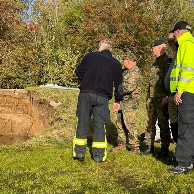 Arnis Hochwasser: Stellvertretender Gemeindewehrführer Axel Kühn, die Vertreter der Bundeswehr und Landrat Dr. Buschmann bei der Begutachtung des Deiches