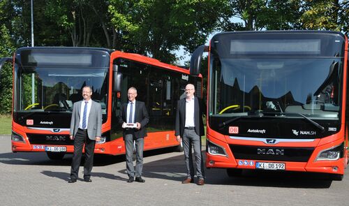 Thorsten Hinrichs, Landrat Doktor Wolfgang Buschmann und Heiko Hecht stehen vor den neuen Bussen.