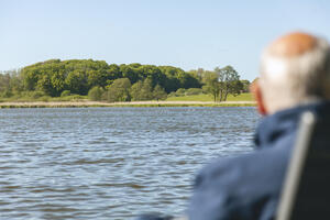 &Auml;lterer Mann schaut &uuml;bers Wasser