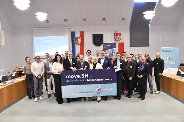 Viele Personen halten gemeinsam ein Plakat hoch von move.SH.
