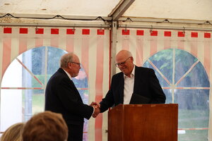 Kreispr&auml;sident Walter Behrens und Redner Dr. Gerhard Ulrich sch&uuml;tteln die H&auml;nde hinter einem Rednerpult